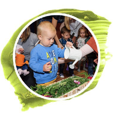 Малыш поливает цветочки на спектакле